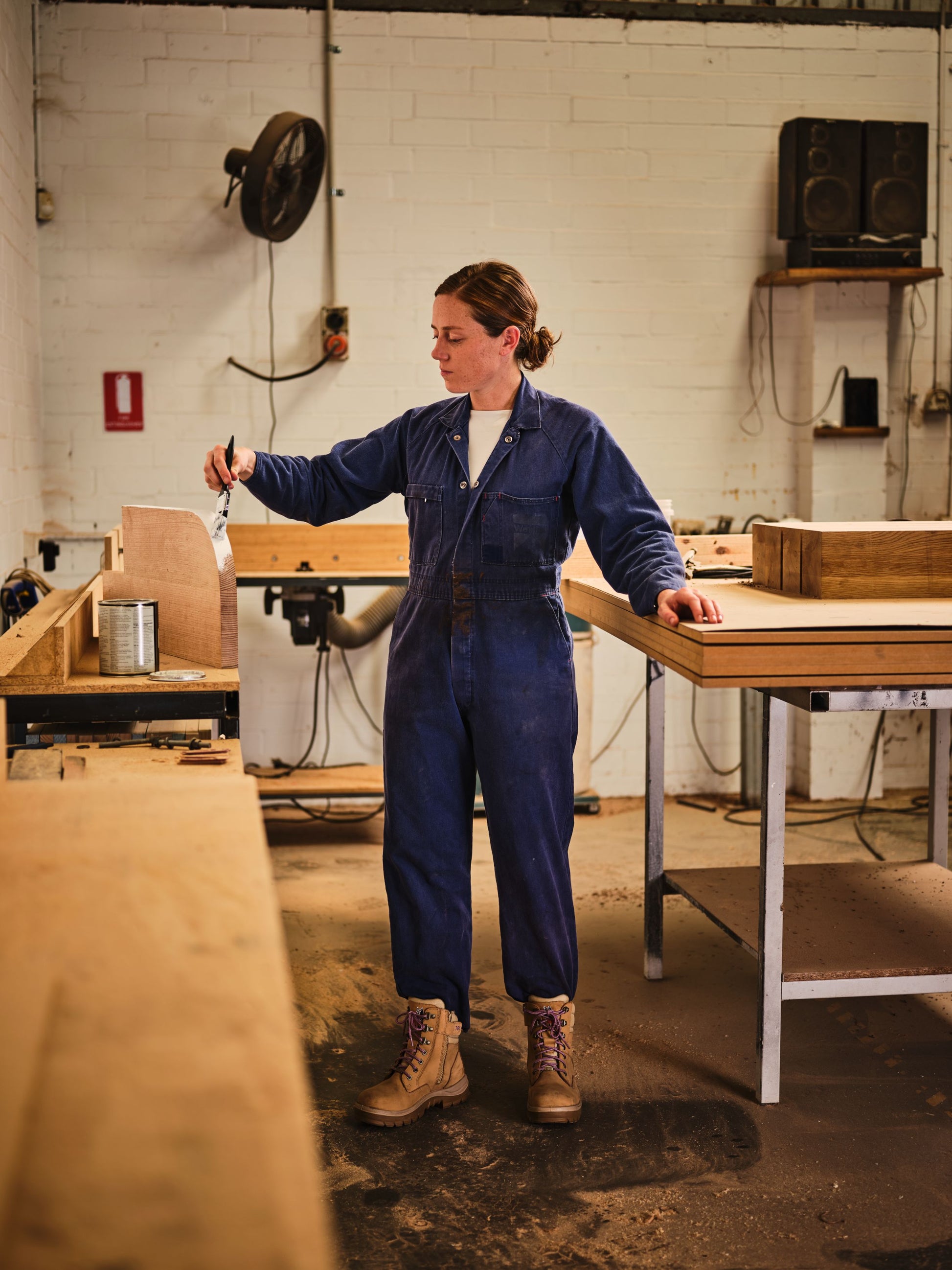 Lady wearing Southern Cross Ladies S3 Safety Boots in sand with zip while painting wood